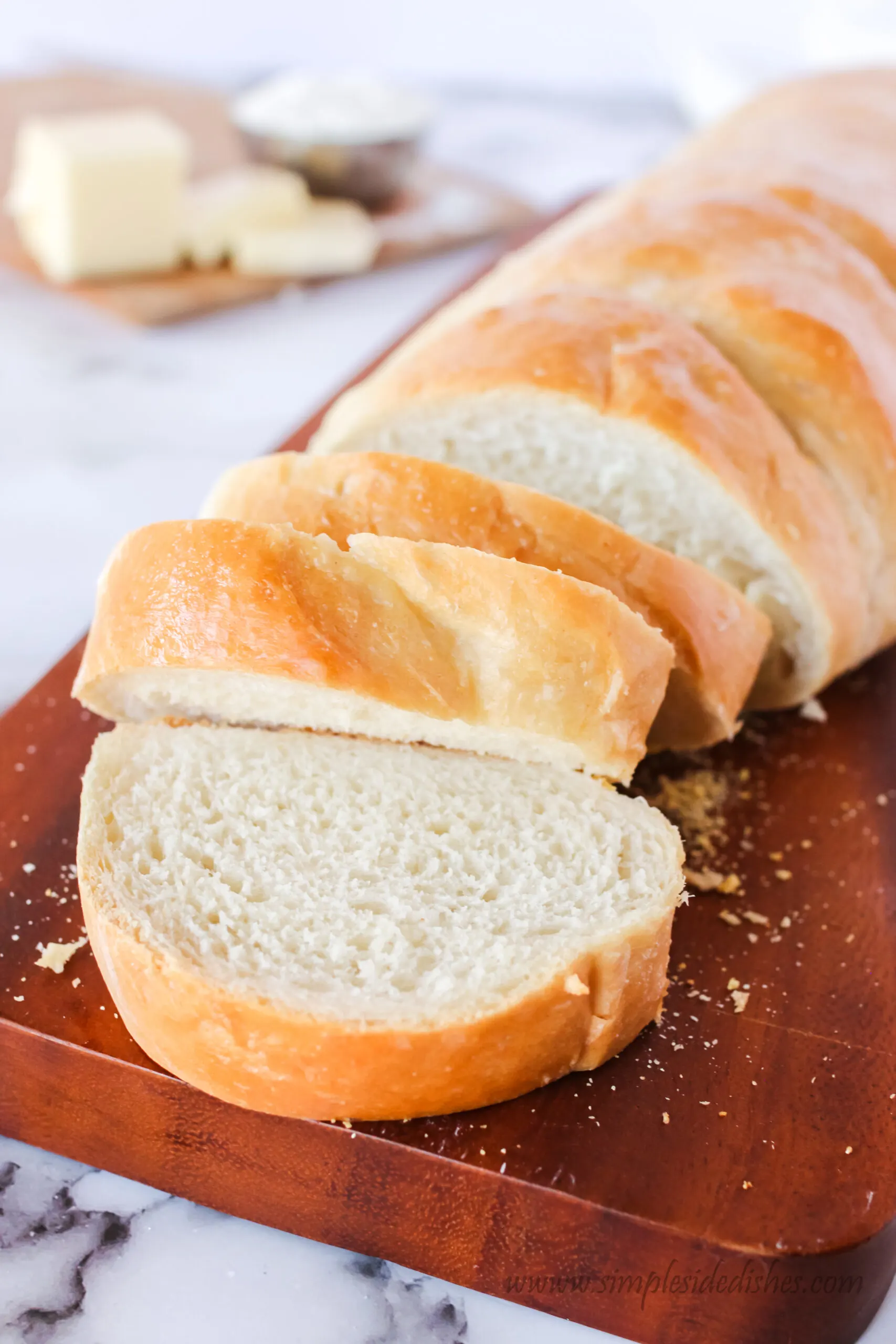 side view of single loaf of bread on cutting board, ready to serve.