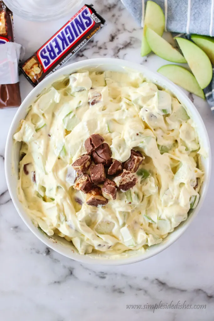 chunks of snickers on top of salad ready to serve.