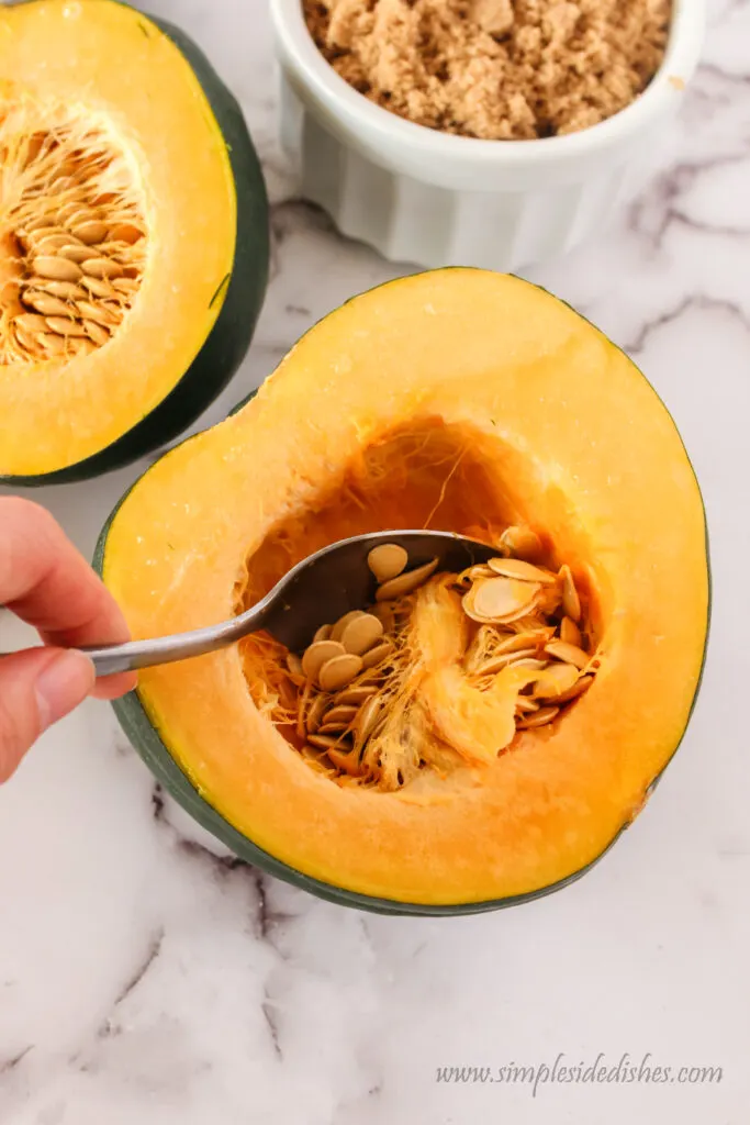 spoon scooping seeds out of squash