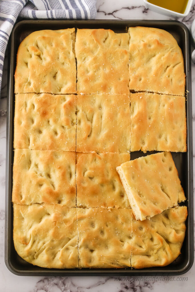 focaccia bread cut into 12 pieces. One of them is popped out