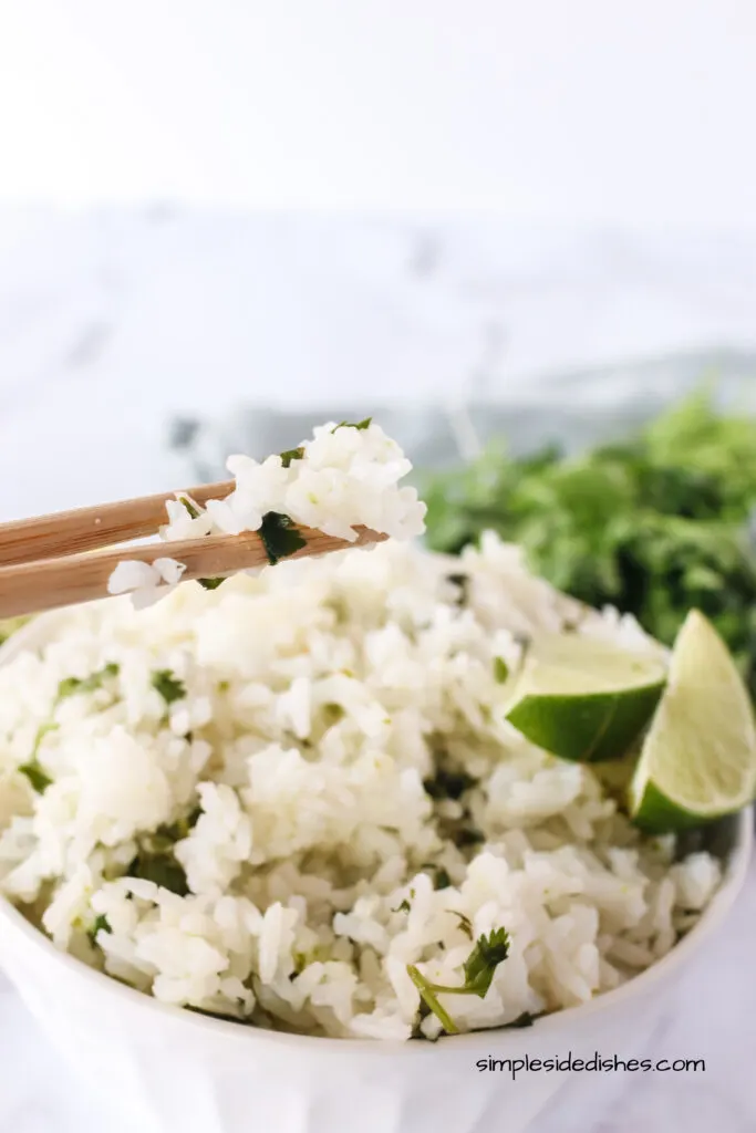 side image of rice in a bowl with chop sticks picking up a few pieces.