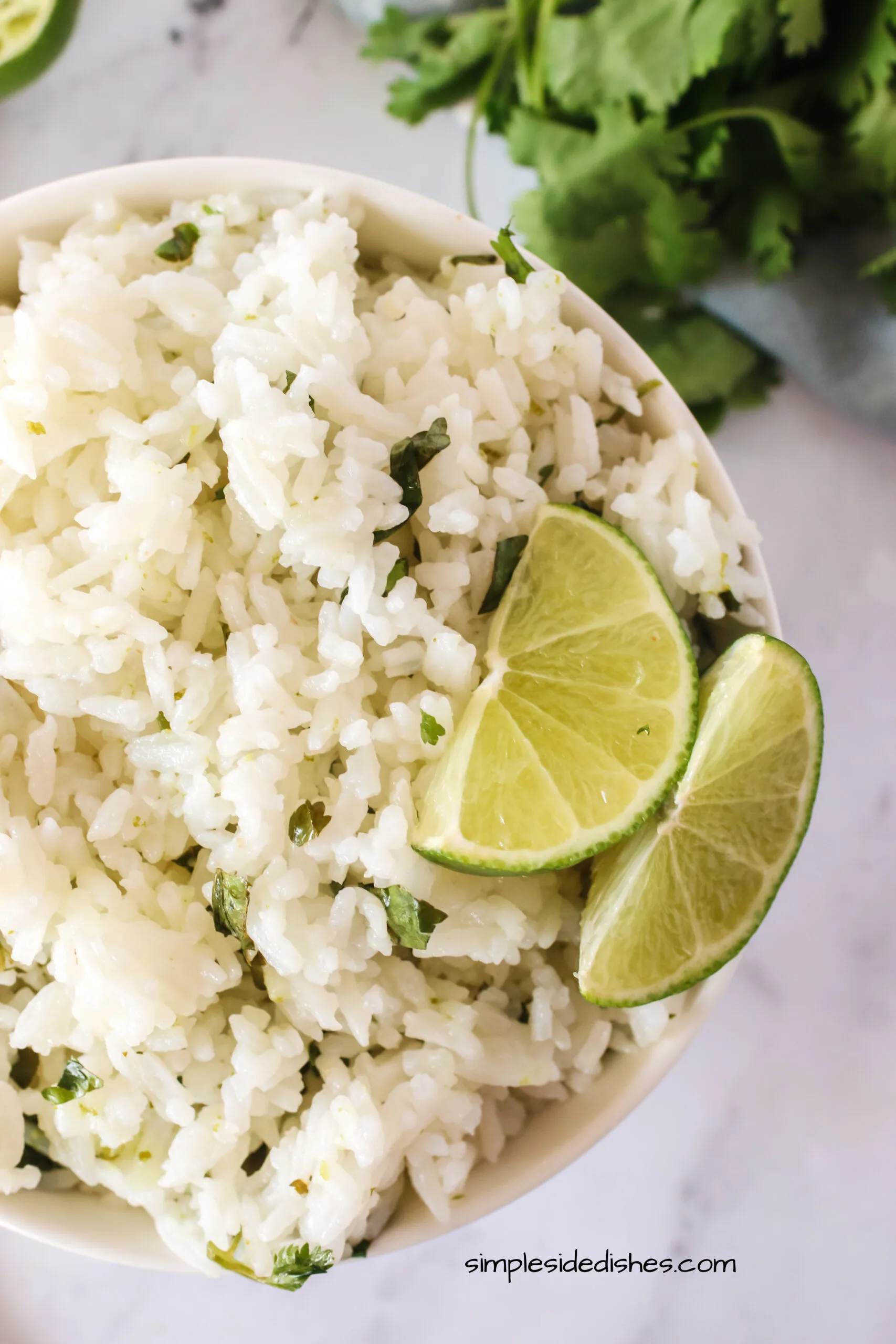 cooked rice in a bowl with lime slices - photo taken from the top looking down.