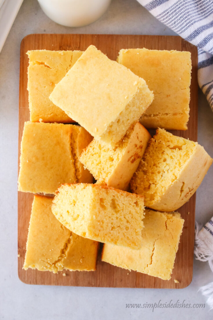 cut up cornbread slices stacked up on a cutting board