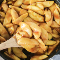 fried apples in skillet with wooden spoon. Photo taken from the top looking down.