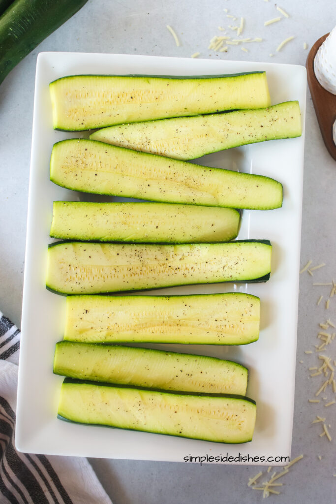 sliced zucchini on a platter, ready for grill