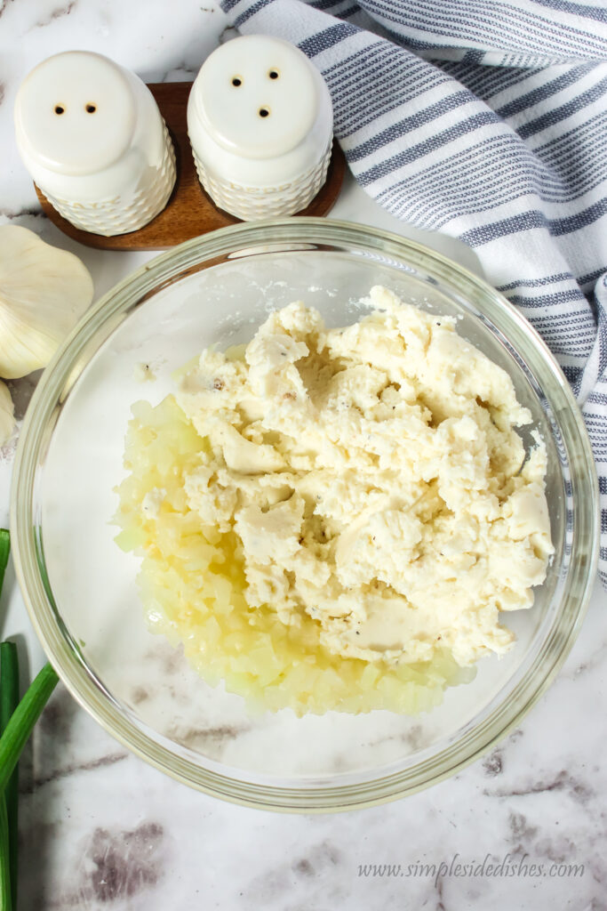 onion mixture in a bowl with mashed potatoes added.