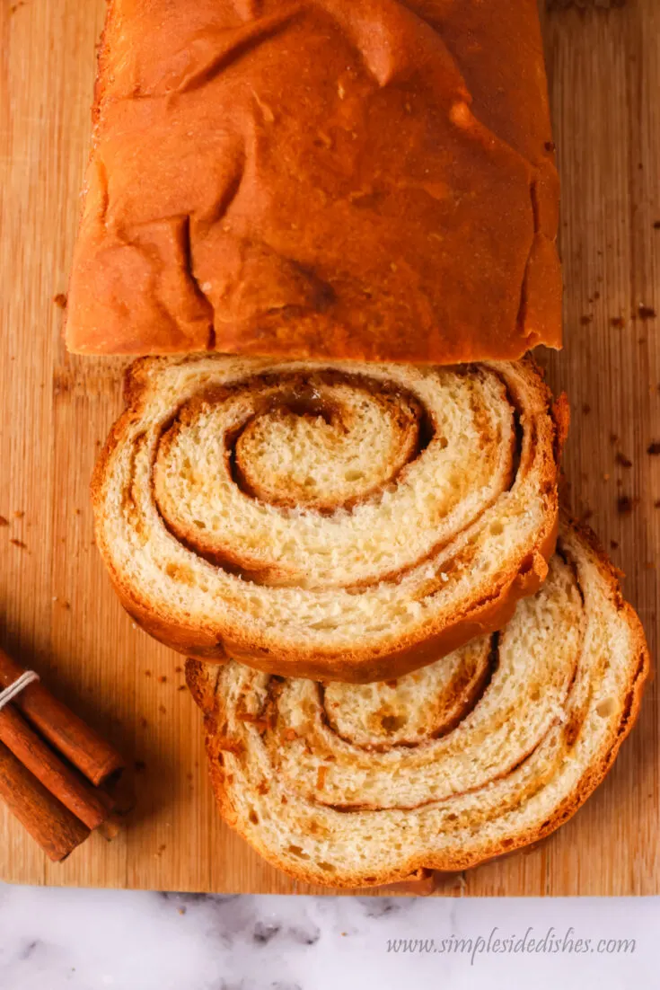 swirled bread on cutting board with 2 slices cut off