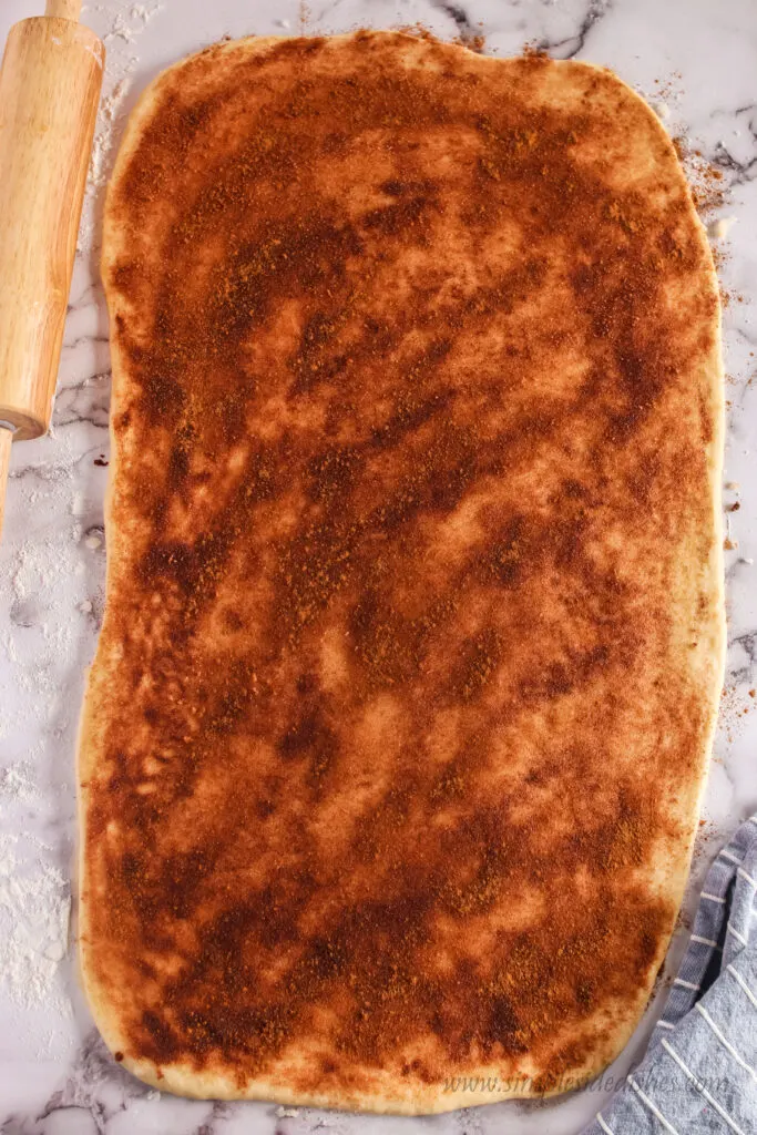 cinnamon sugar spread over rolled out dough