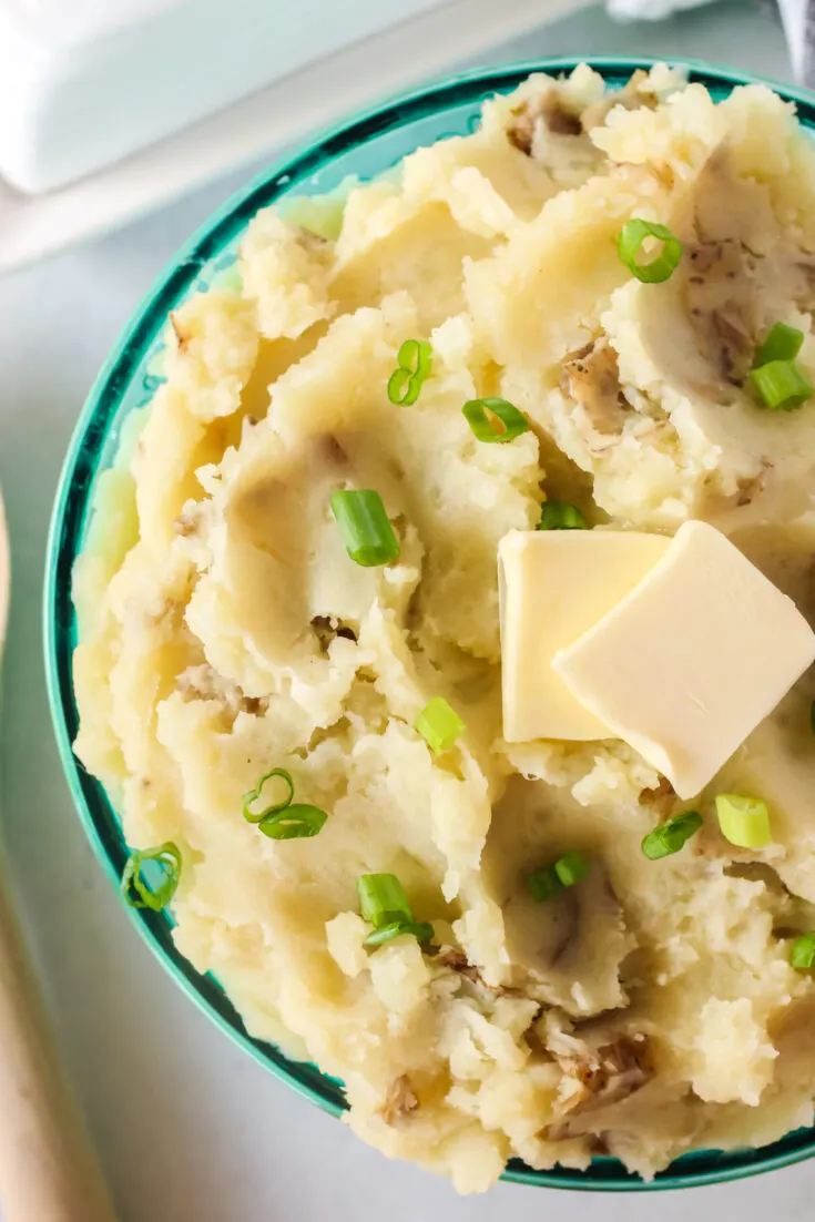 zoomed in image of mashed potatoes in bowl with butter