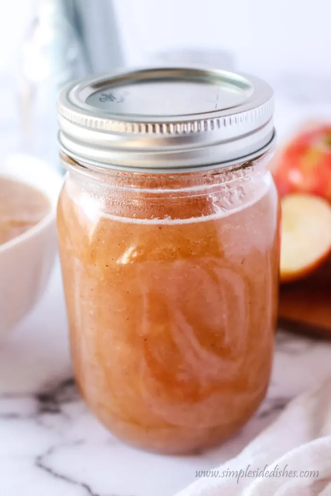 side view of applesauce in a glass jar for storage