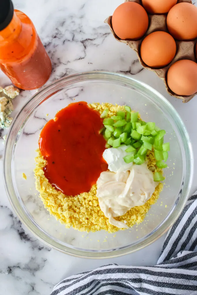 mayonnaise, sour cream, celery and buffalo sauce added to mashed egg yolks