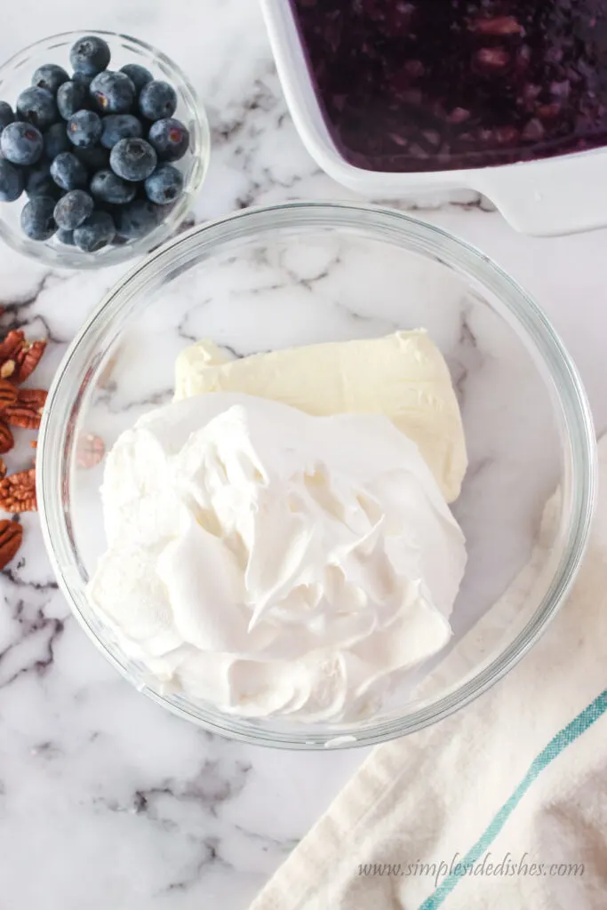 cool whip and cream cheese in a bowl, unmixed