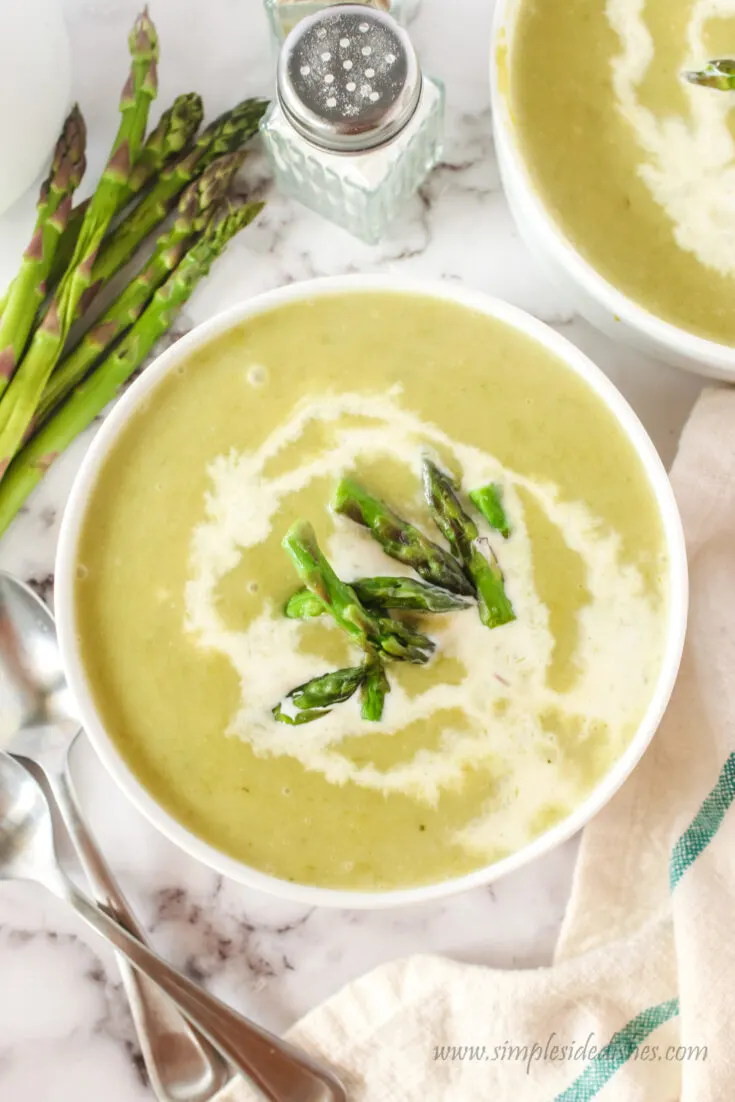 two bowls on table of asparagus soup. Photo taken from the top looking down.