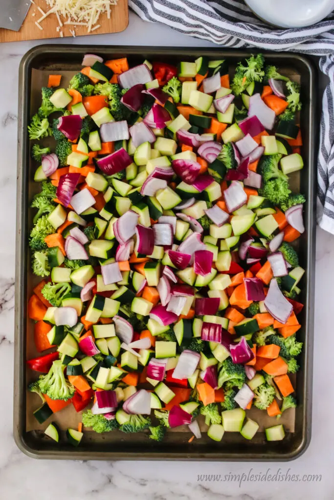 cut up vegetables on cookie tray ready to season