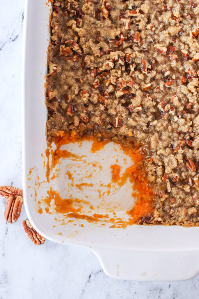 Pecan Sweet Potato Casserole in pan with a single portion removed