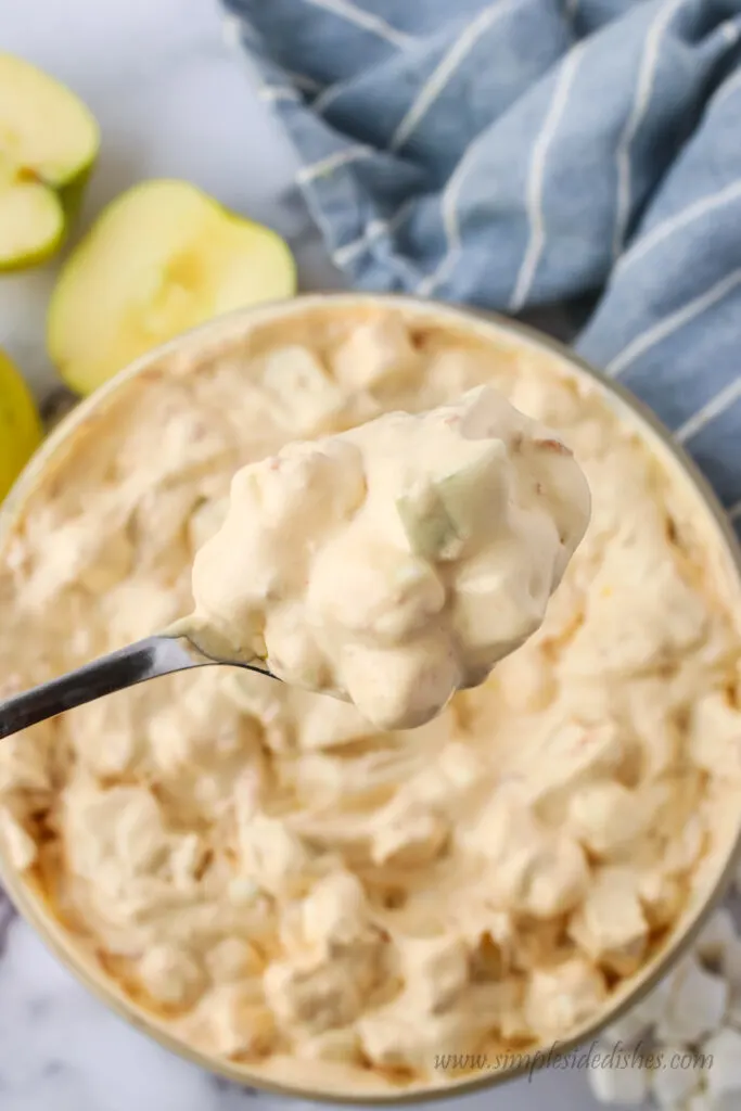 caramel apple fluff in bowl with a spoon scooping some out