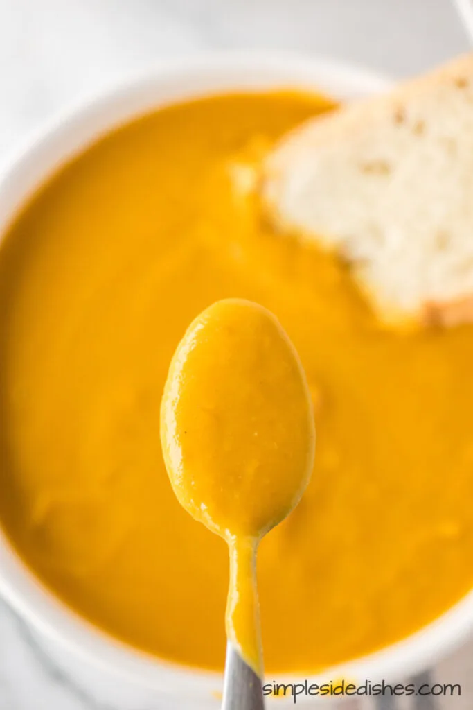 bowl of soup with a spoonful being held above.