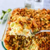 Baked Cheesy Broccoli Stuffing Casserole in pan with a spoon scooping a portion out.