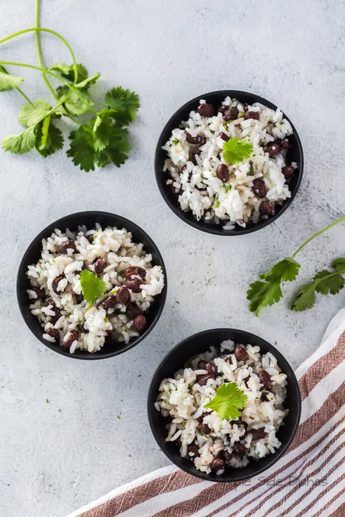 top view looking down at 3 bowls of black beans and rice