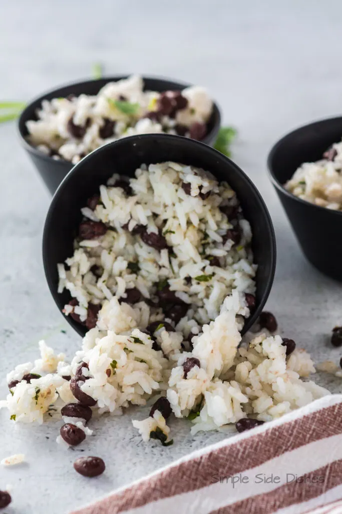 3 bowls of black beans and rice with the front bowl tipped over