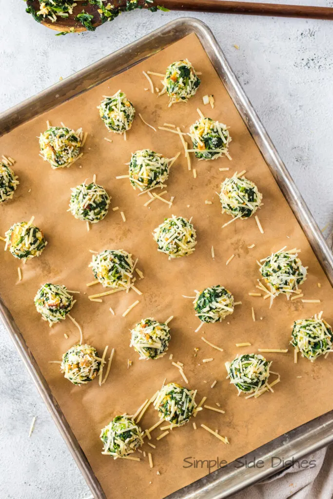 spinach stuffing balls laid out on a lined cookie sheet
