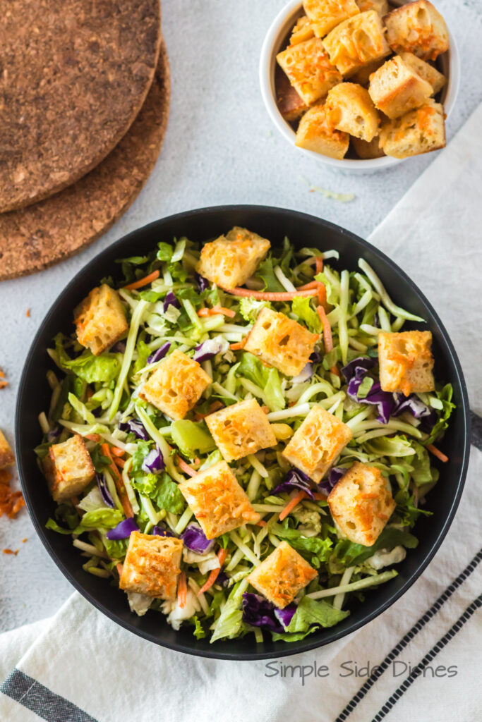 zoomed out image of baked parmesan garlic croutons on a salad