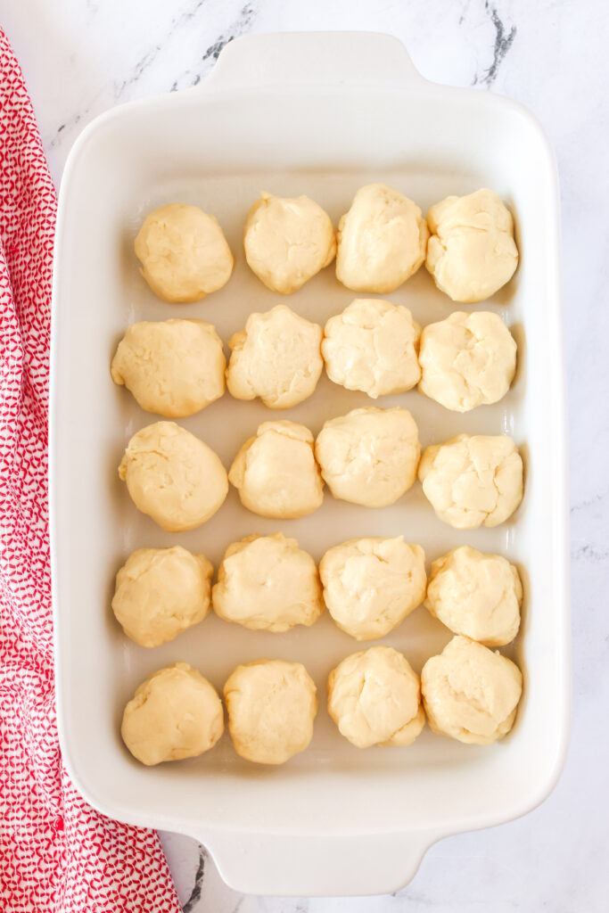 20 round dough balls in a casserole dish, unrisen