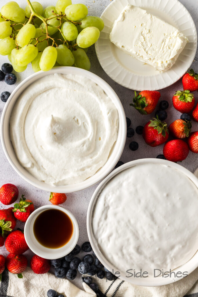 All ingredients for cool whip fruit dip are laid out on counter with fruit