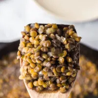 wooden spoon scooping out a portion of lentils