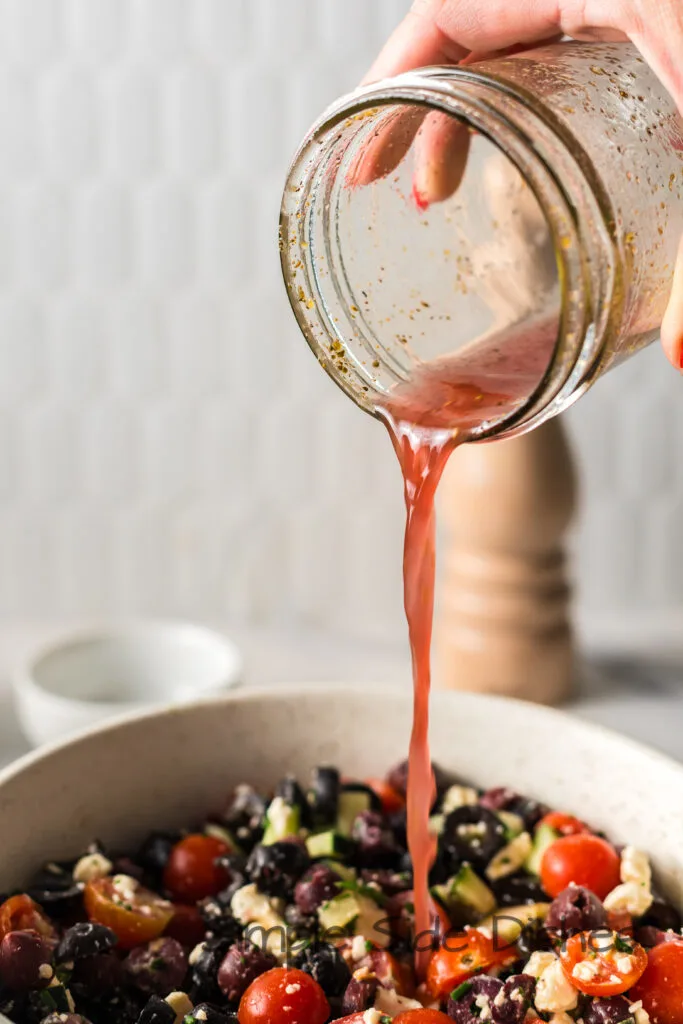 red win vinaigrette being poured on salad