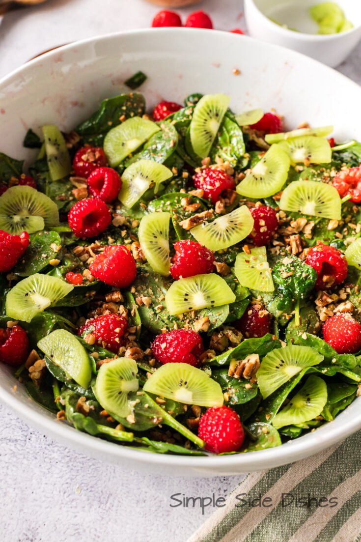 finished salad with raspberries, kiwi and pecans, ready to serve