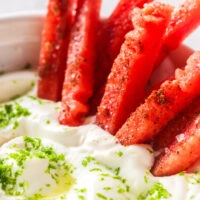 zoomed in image of watermelon sticks in coconut cream sauce.