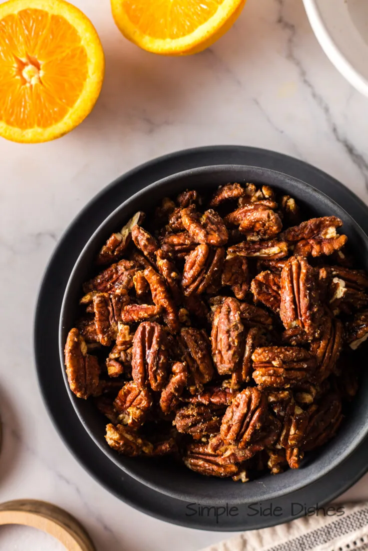 orange candied pecans in a serving bowl ready to eat.