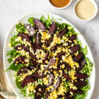 Full view of salad on a bed of lettuce with dressing on the side.