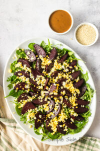 Full view of salad on a bed of lettuce with dressing on the side.