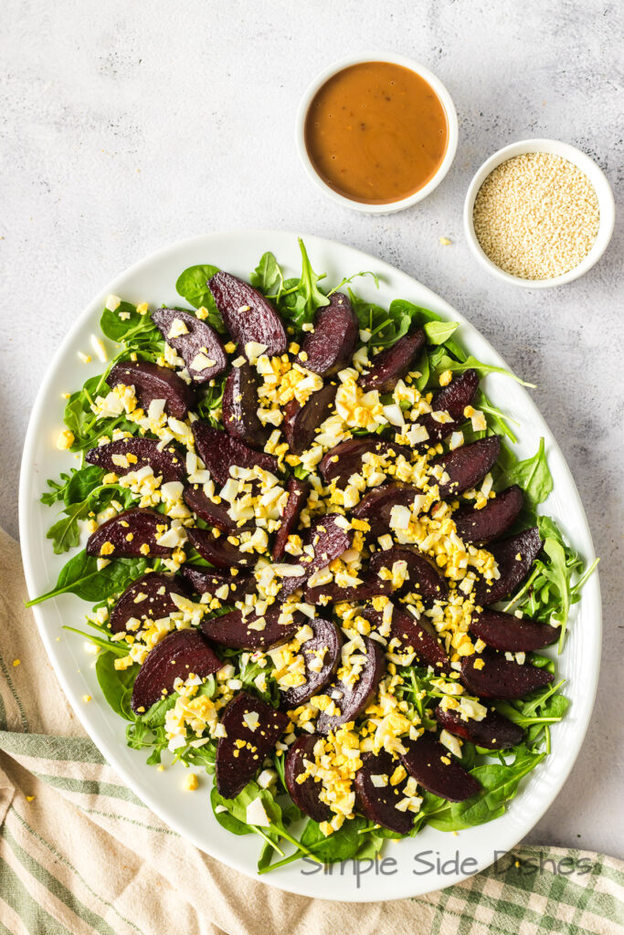 Full view of salad on a bed of lettuce with dressing on the side.