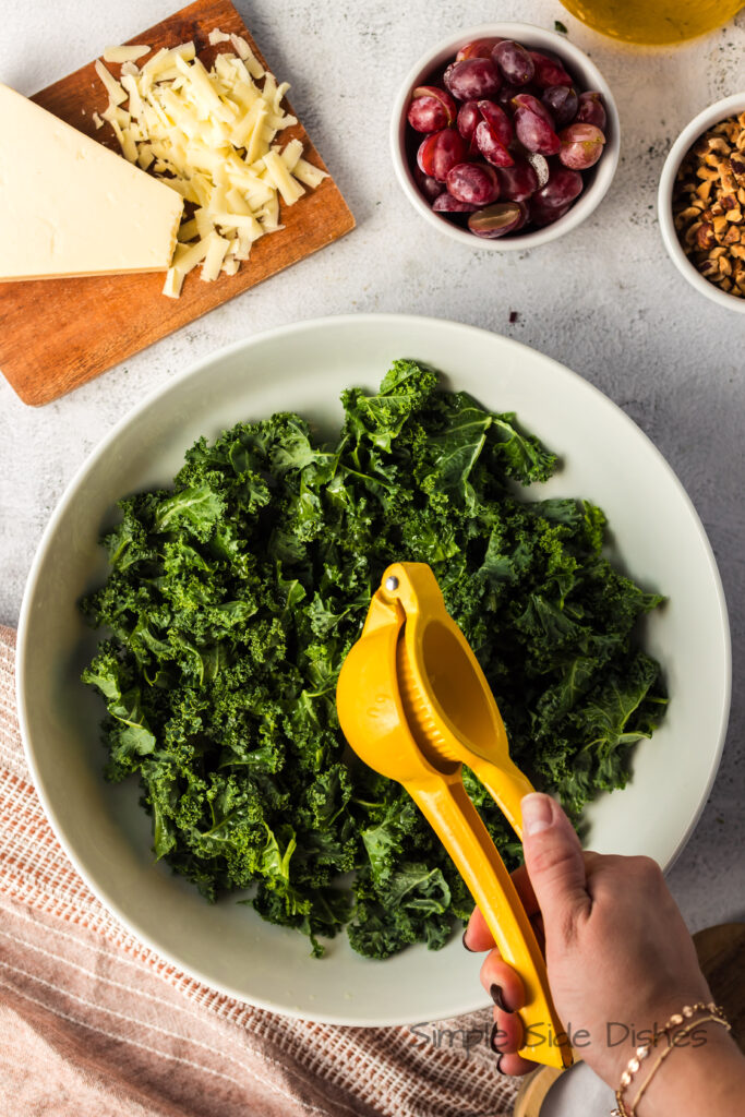fresh squeezed lemon being juiced over kale.
