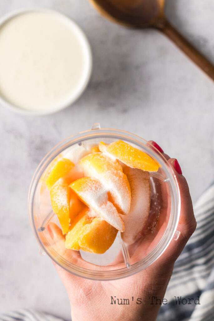 thawed frozen peaches and sugar in blender.