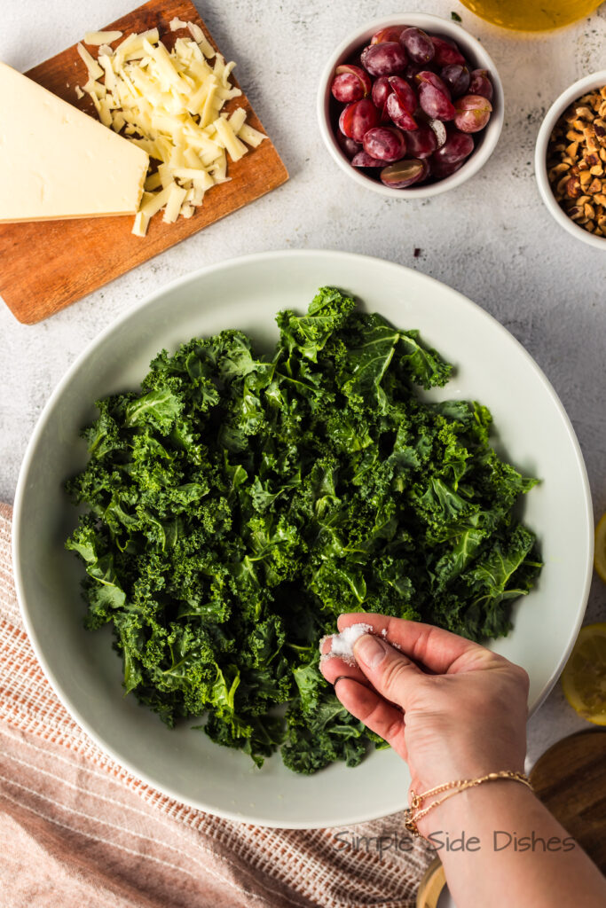 a sprinkle of salt being added to kale.